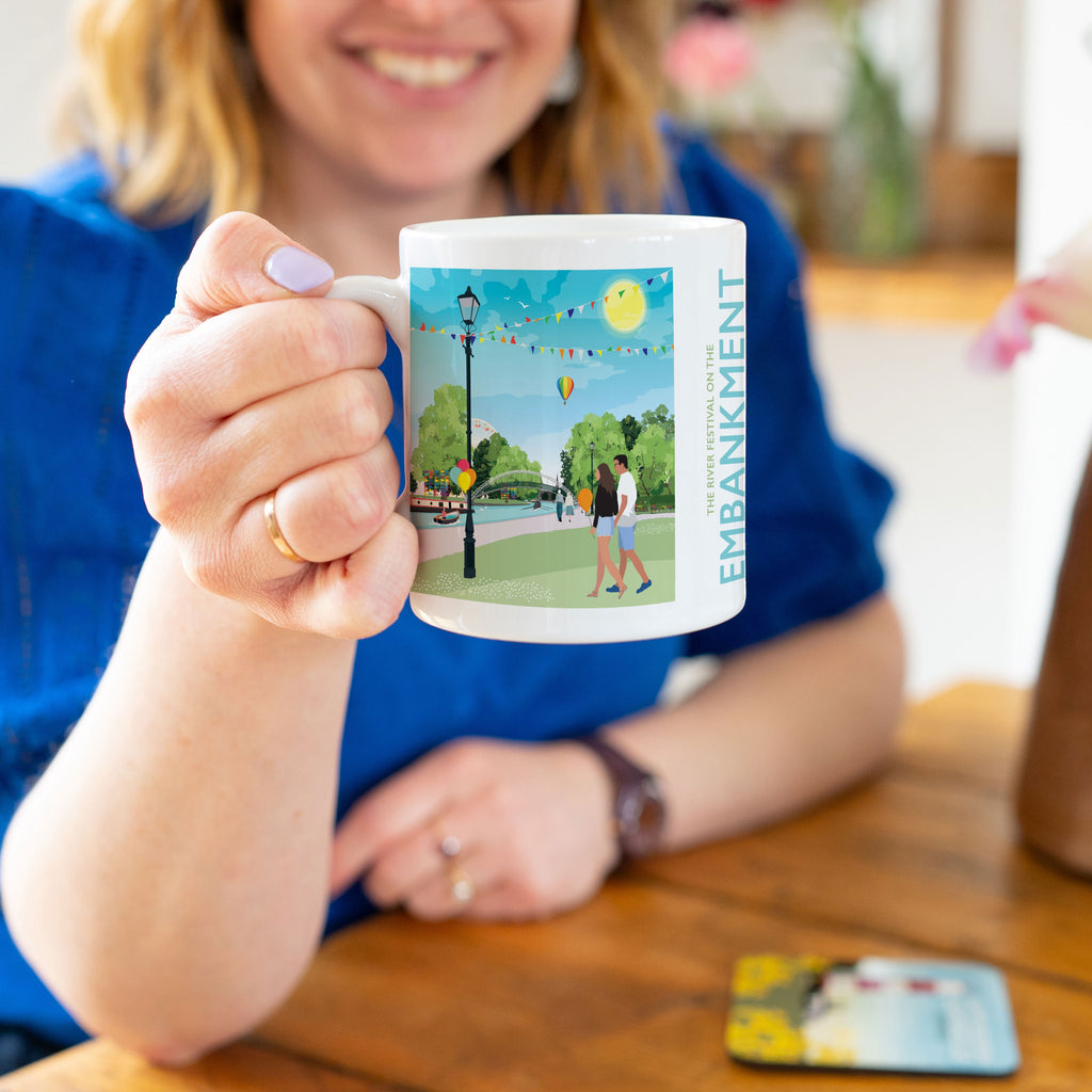 a woman sitting at a table holding a coffee mug